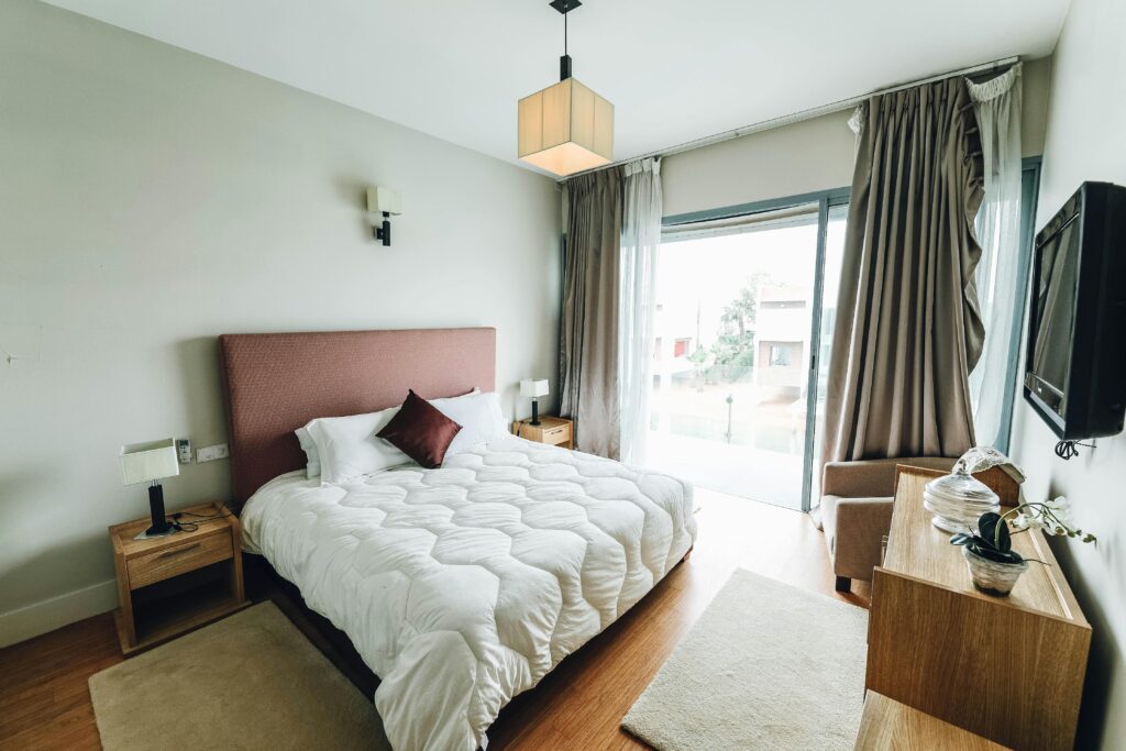Bright and elegant bedroom featuring minimalist decor and a large window view.
